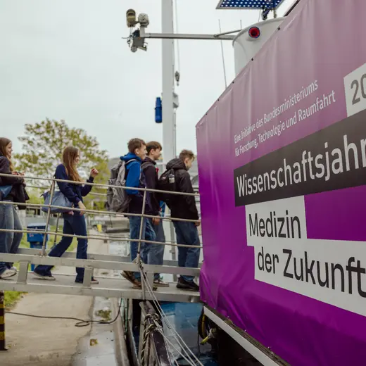 Eine Schulklasse betritt über einen Steg das Schiff MS Wissenschaft