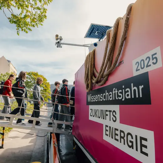 Schüler*innen gehen über einen Steg aufs Schiff. Rechts ist das Logo des Wissenschaftsjahres auf dem Schiff zu sehen.